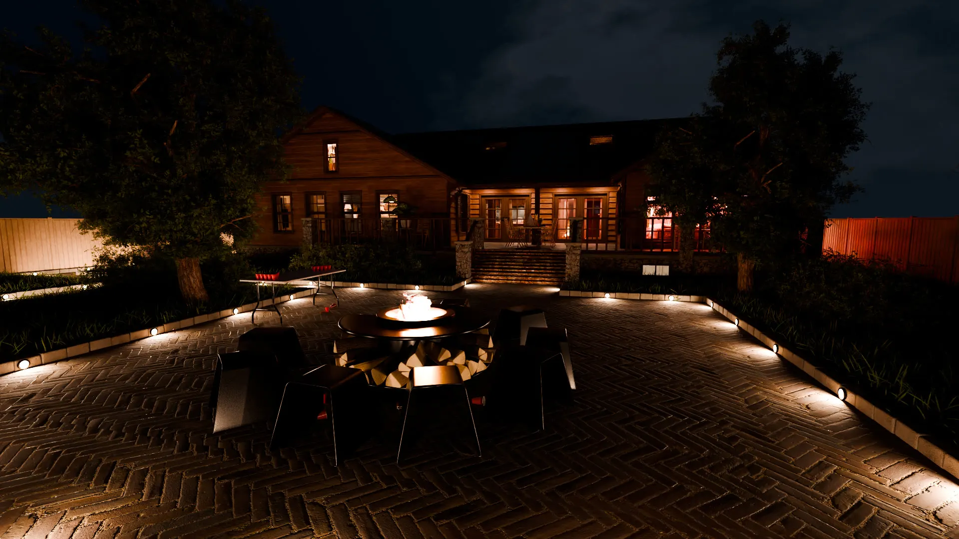 A firepit terrace picked out by ground lighting.